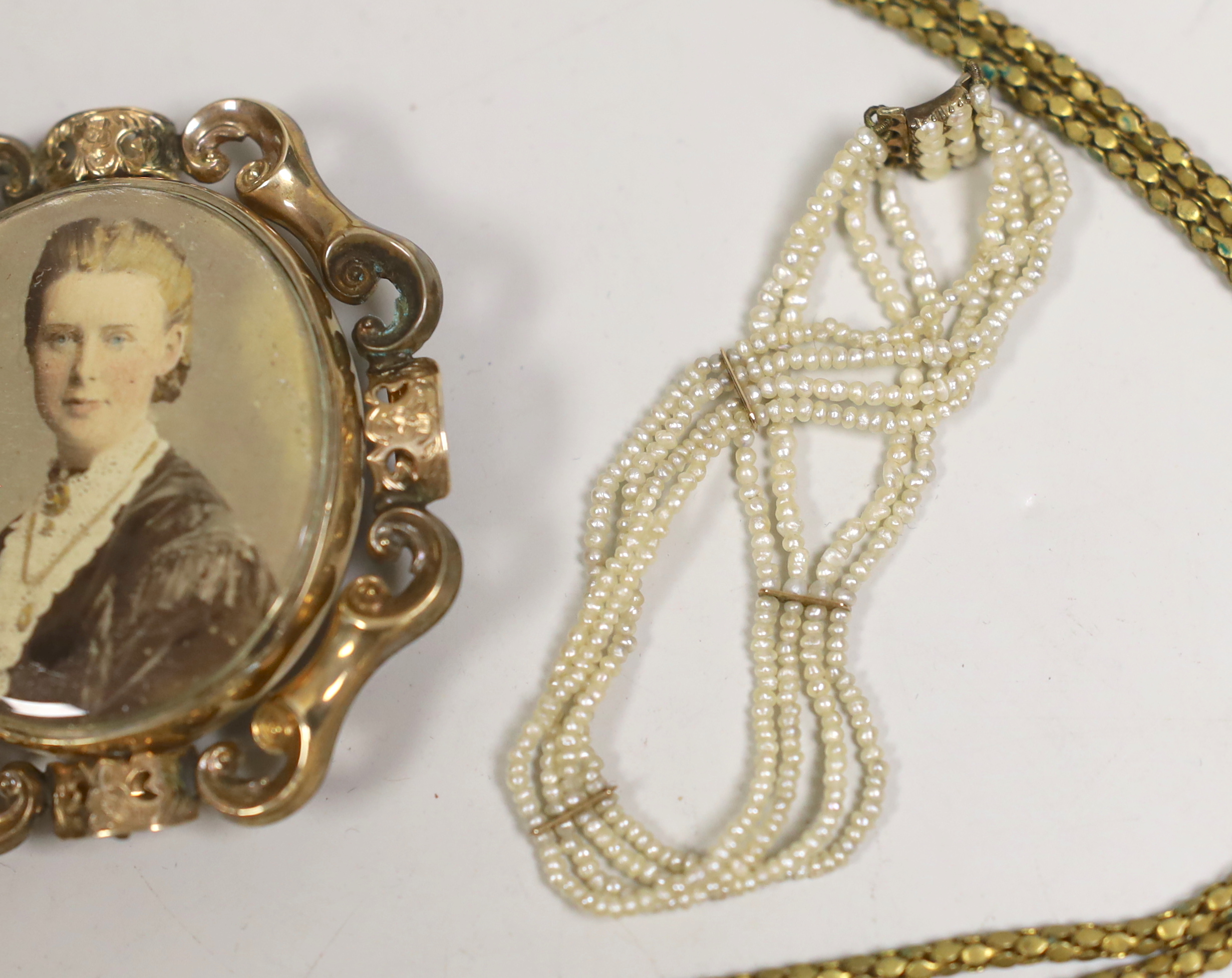 A 19th century yellow metal overlaid and bloodstone set fob seal, 22mm, on a yellow metal mounted black sash, a similar gilt metal guard chain and mourning pendant and a Regency seed pearl bracelet.